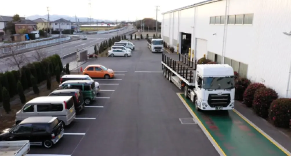 小久保鉄筋工業株式会社の外観。駐車場に止まっているたくさんの車。